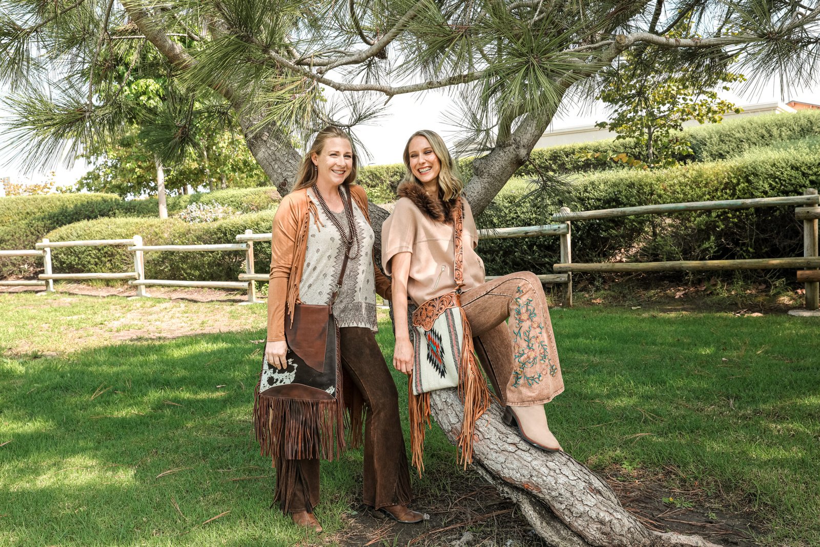 Two women in Western fringe outfits with fringe bags and boots from Dluvz Boutique
